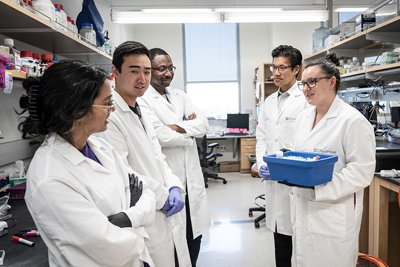City of Hope researchers talking in the lab.